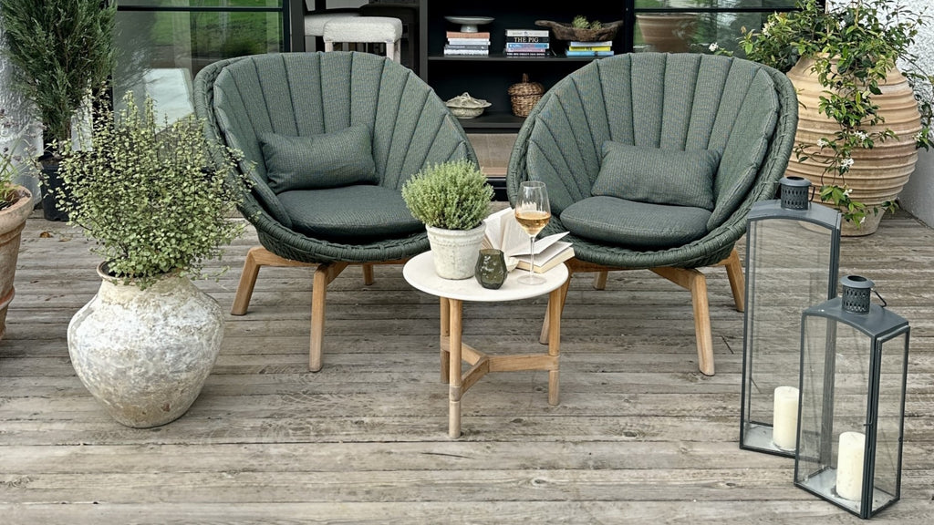 Terrace decor with two dark green lounge chairs white a small side table