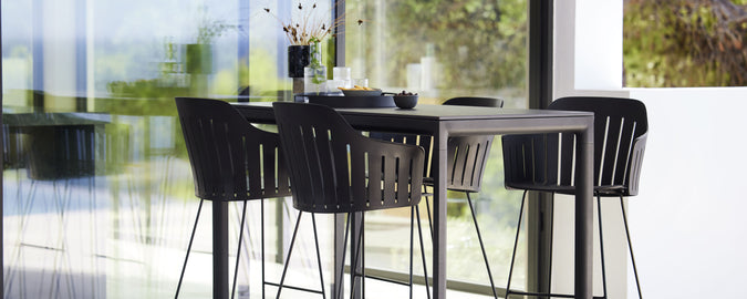 Modern bar table with matching stools, featuring sleek design and minimalist aesthetics, perfect for social gatherings and relaxation.