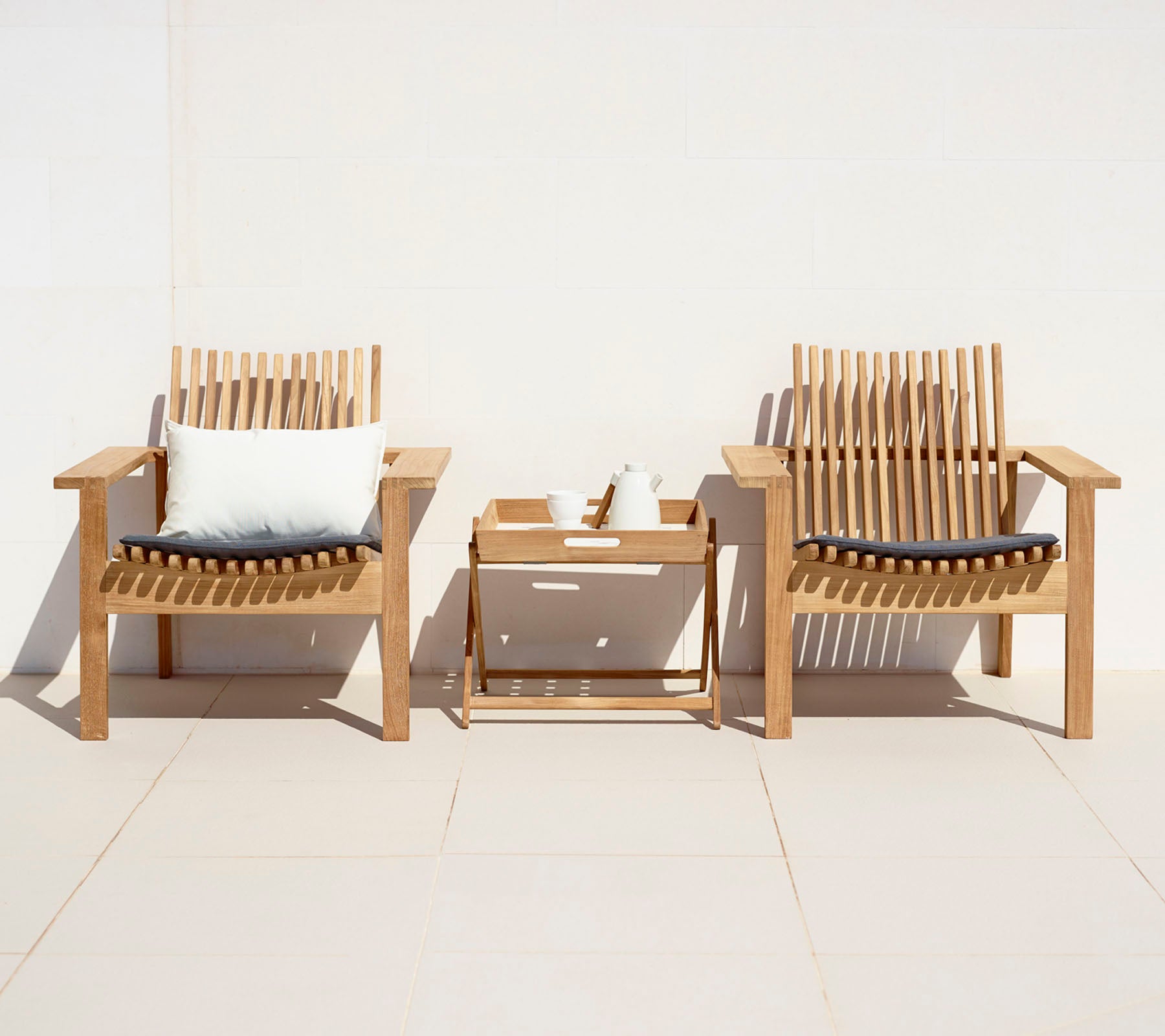 Two stylish wooden chairs with cushions and a small side table, creating a cozy seating area.