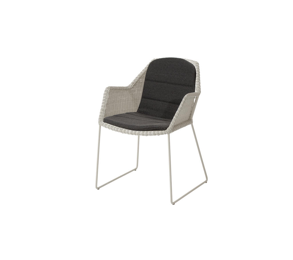 Modern chair with sand frame and dark grey cushion.