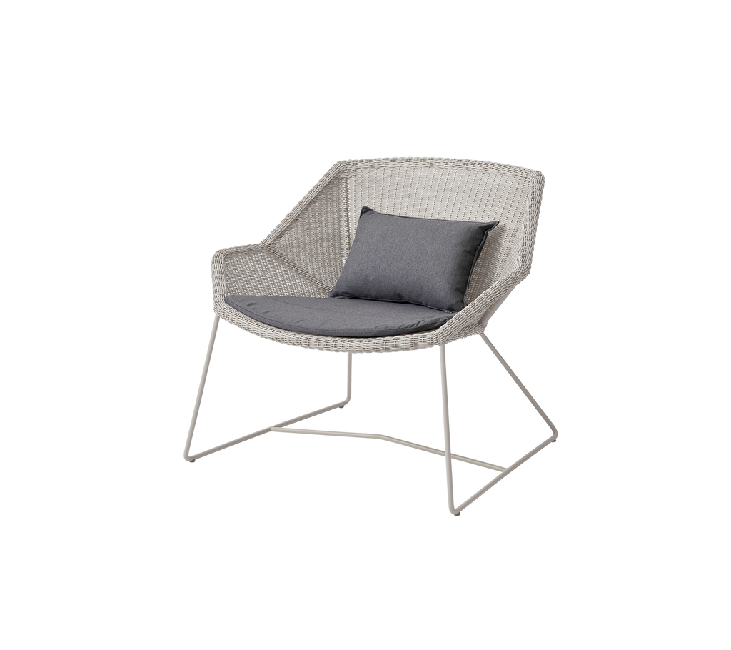 Modern chair with a grey cushion in a contemporary lounge setting.