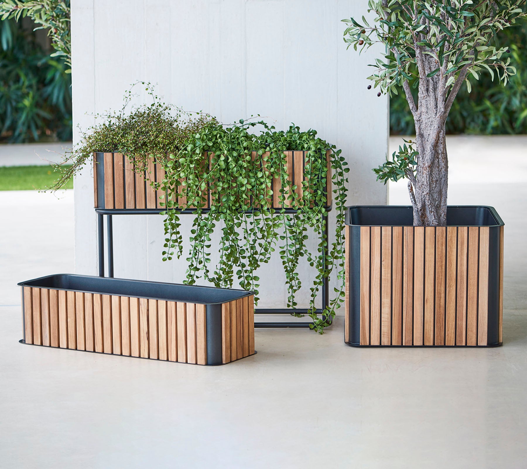 Three stylish planters with wooden slats and metal bases, showcasing lush greenery and adding a touch of elegance to any space.