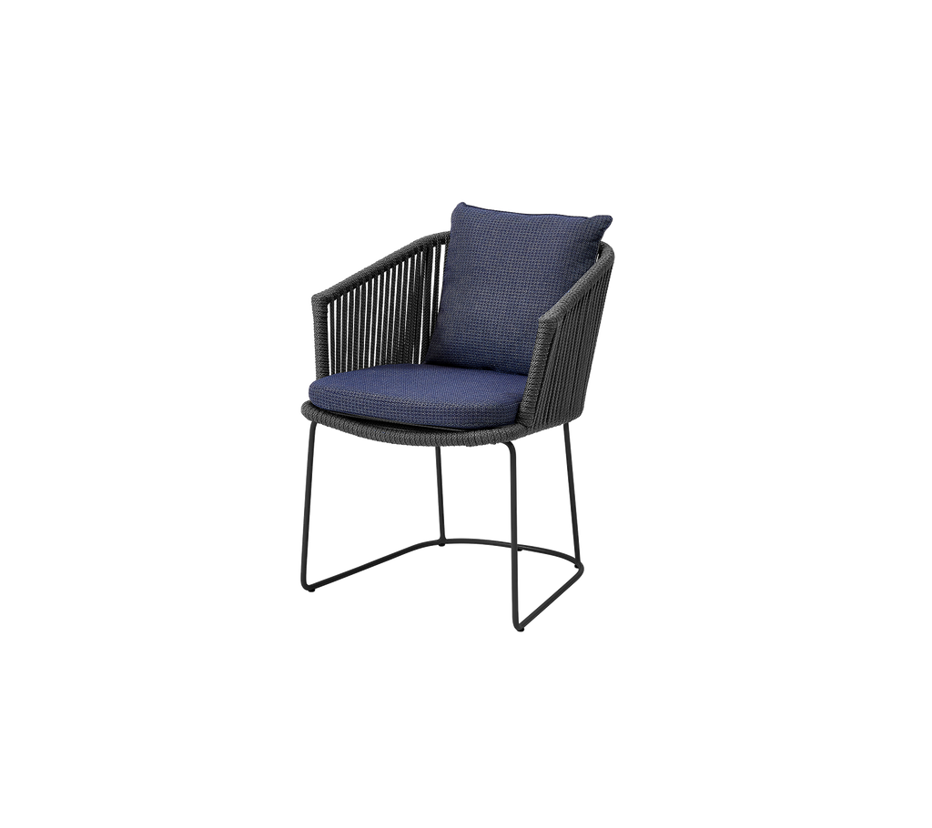 A stylish outdoor chair with a dark wicker frame and a deep blue cushioned seat and backrest, perfect for relaxation.