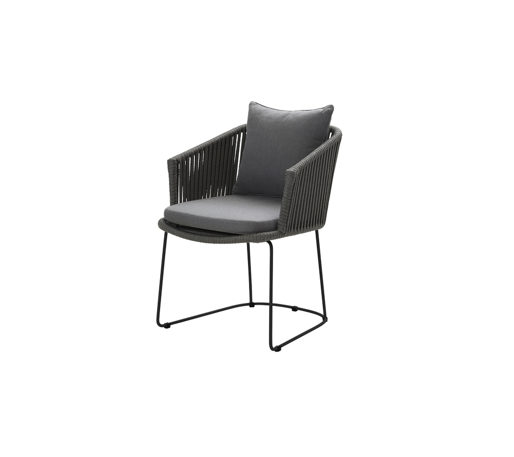 Stylish lounge chair featuring a gray cushion, a woven backrest, and a sleek black metal frame. Perfect for modern decor.