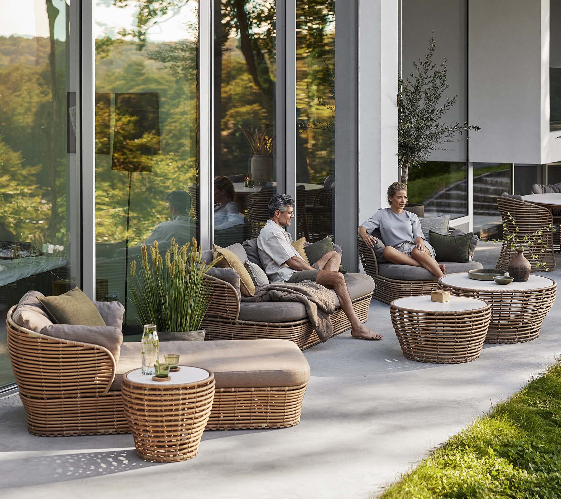 Stylish seating area featuring a basket sunbed, lounge chair, and coffee table with natural elements, creating a cozy, relaxing atmosphere.