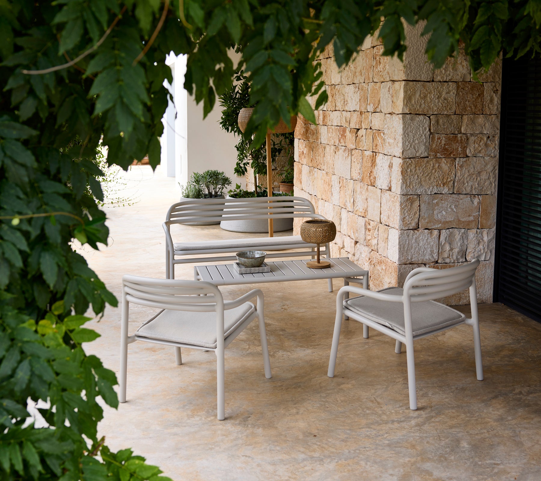 Grey sofa and chair with a white table in a modern lounge setting.