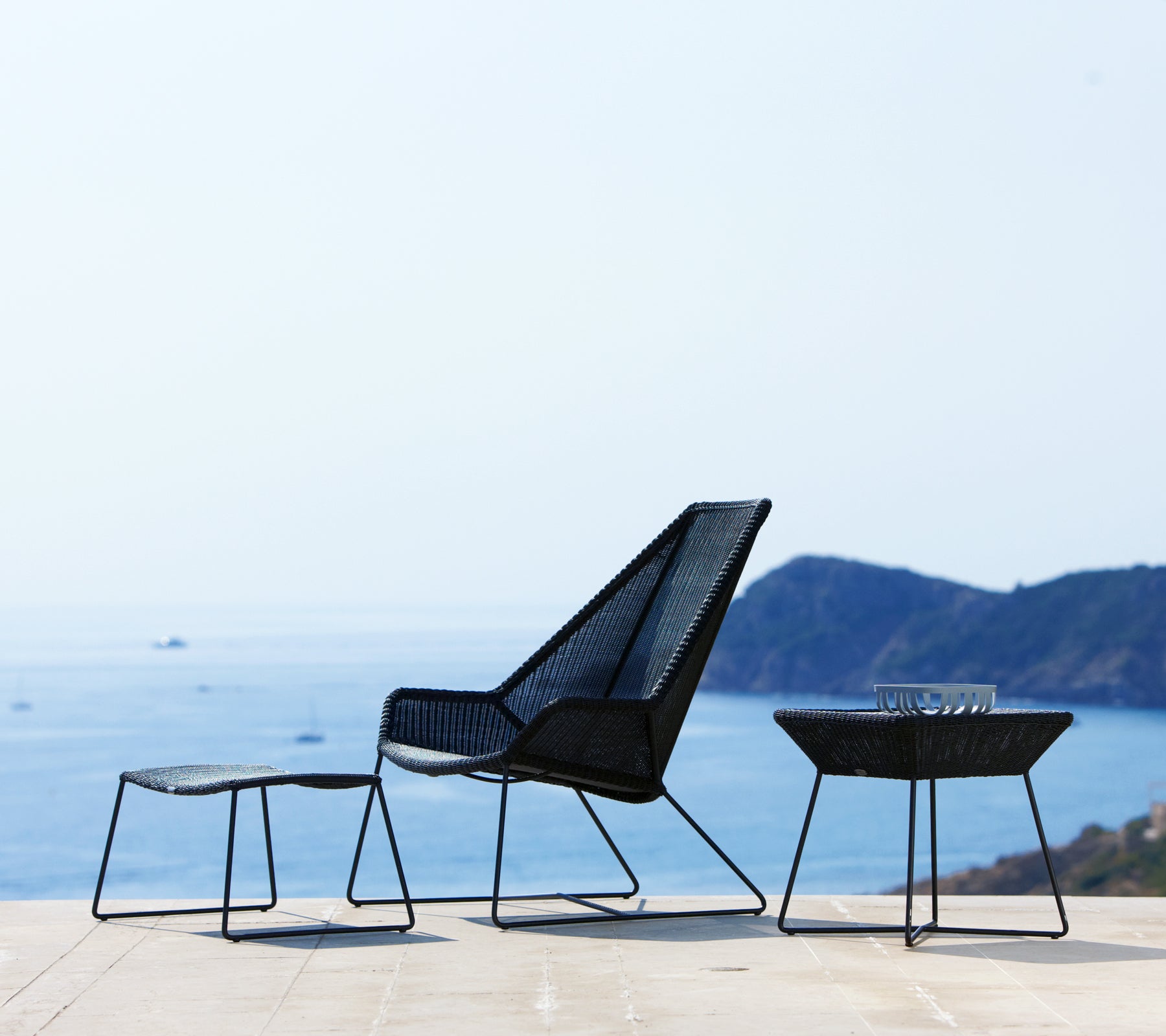 Modern black chair and tables overlooking the ocean.
