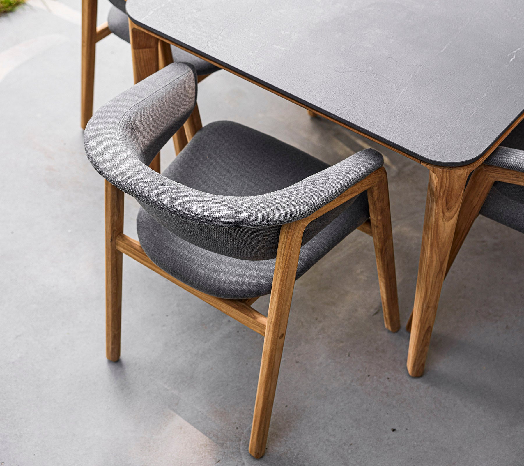 Stylish chair with a wood frame and soft grey upholstery, designed for comfort and elegance. Perfect for modern dining spaces.