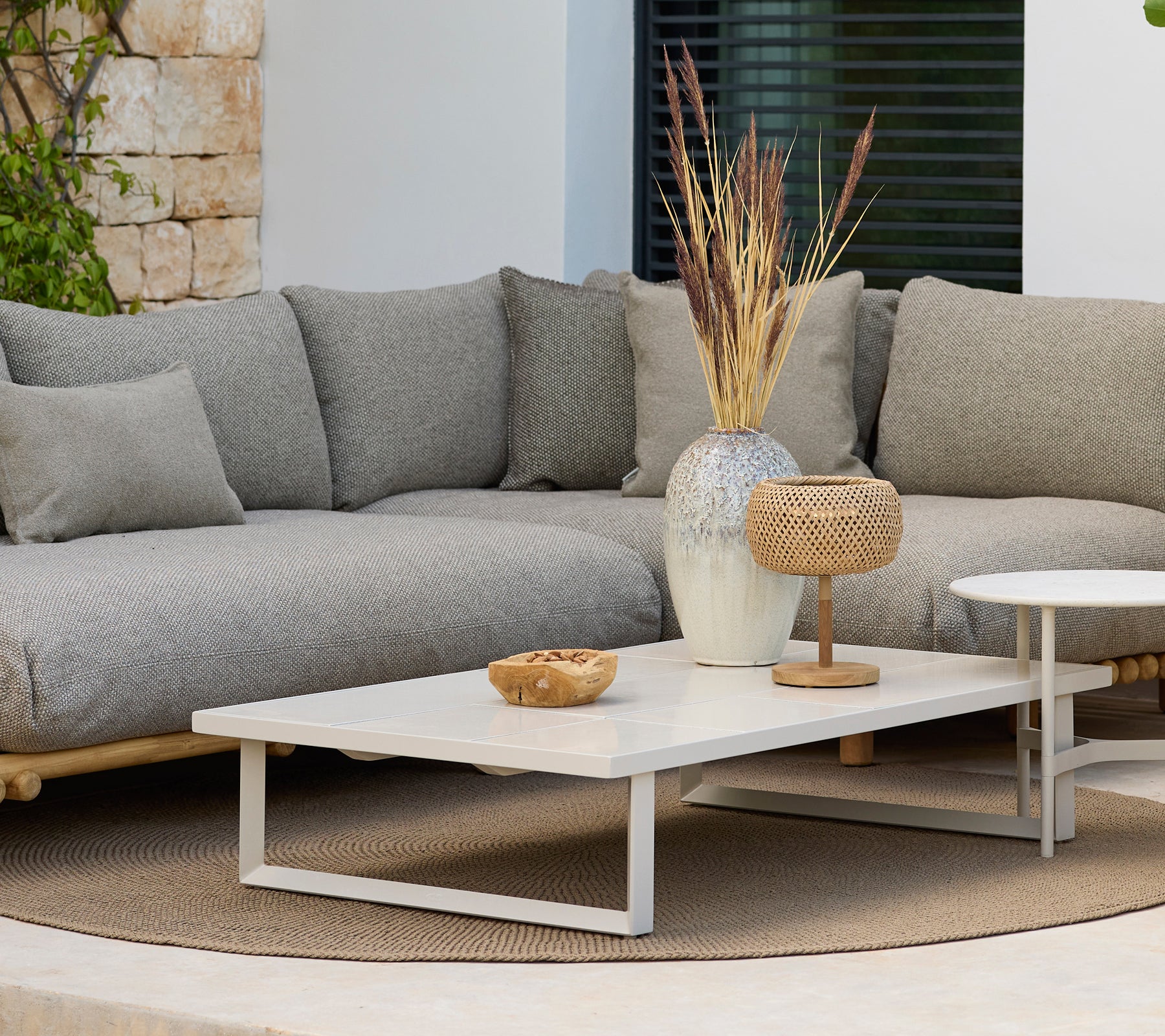 Modern lounge area featuring a grey sofa and a white coffee table with decor.