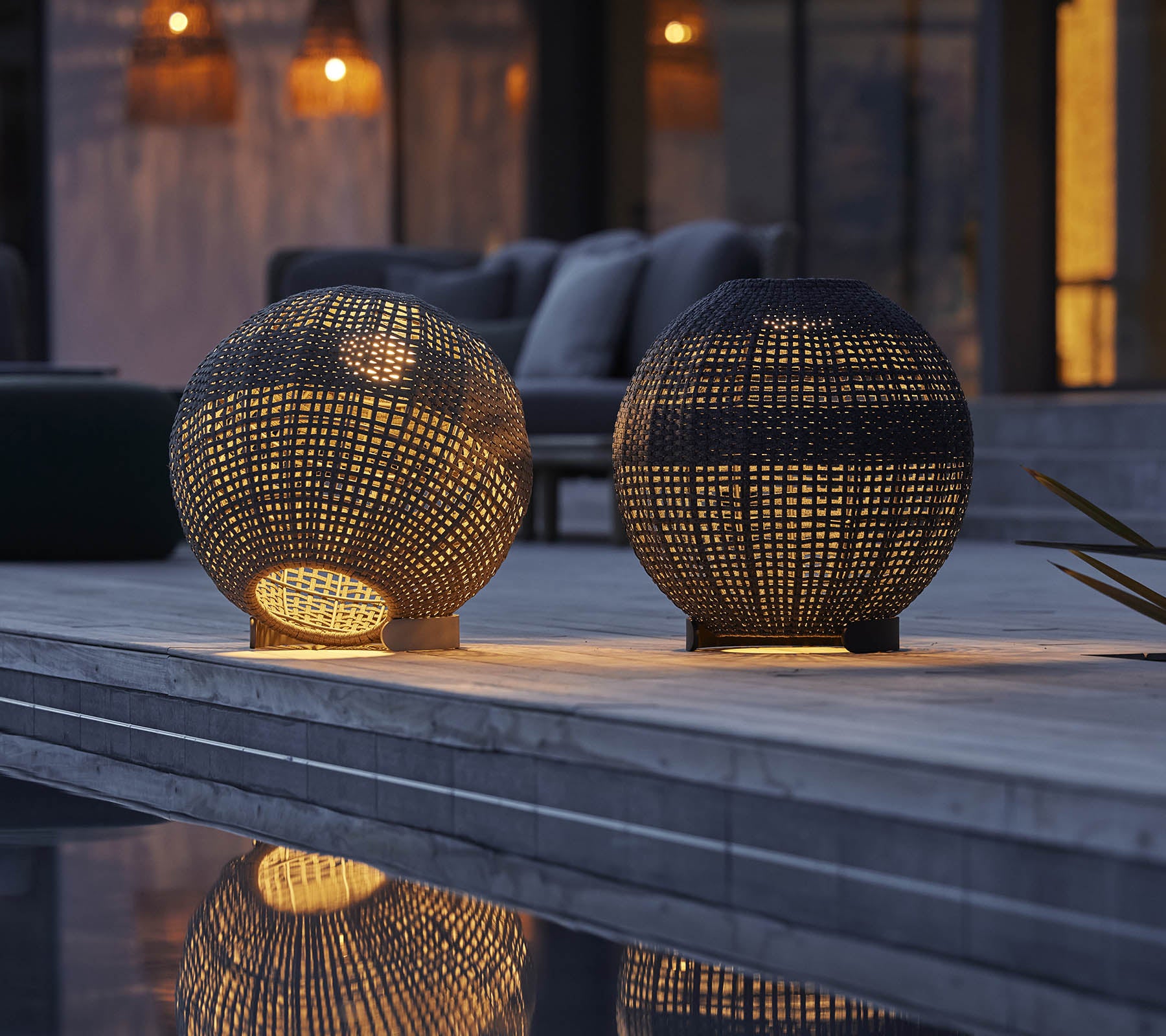 Two round illusion lamps with intricate patterns, casting warm light and reflections on a surface, creating a cozy atmosphere.
