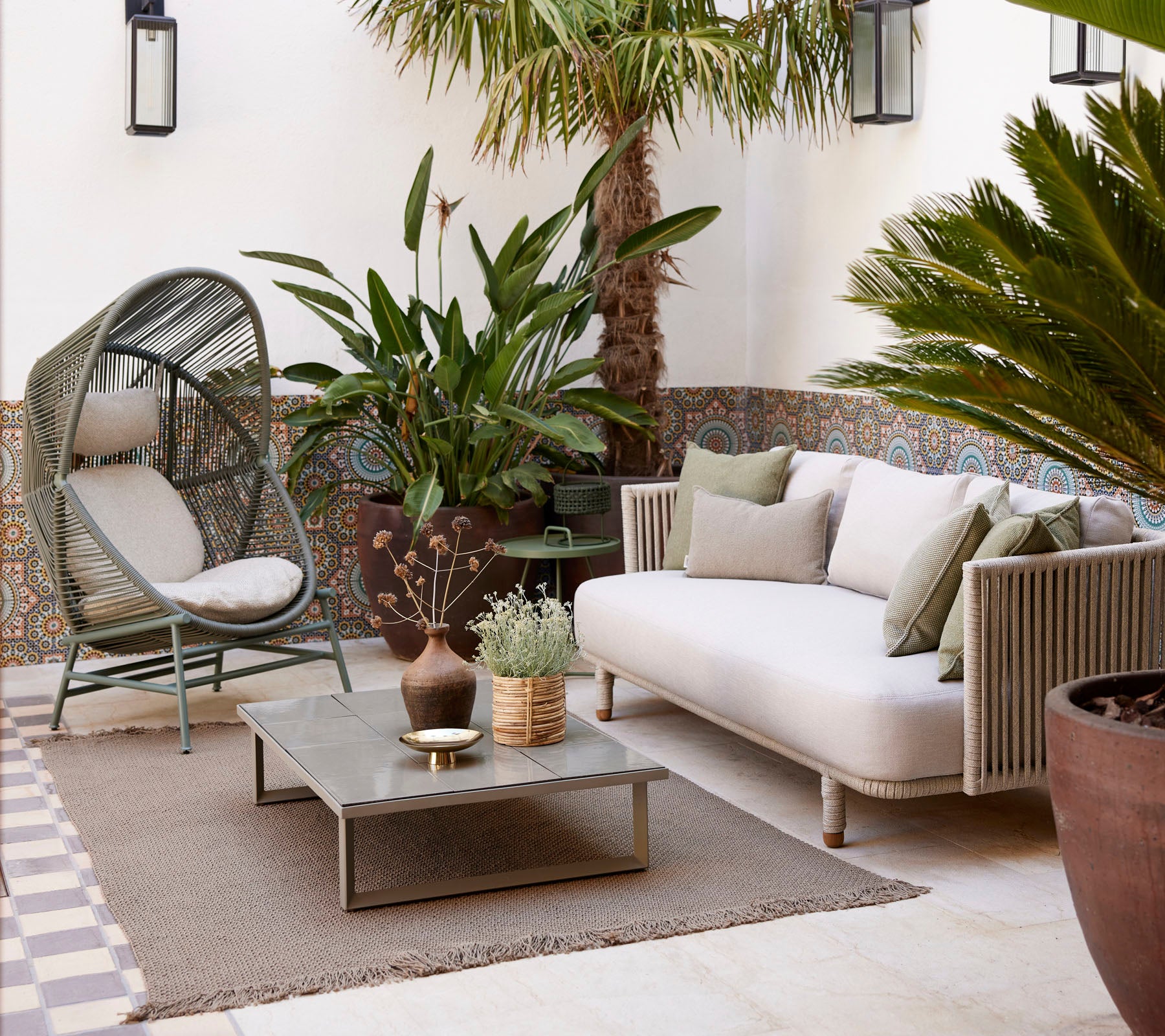 Cozy seating area with plants, textured rugs, and a modern coffee table, offering a serene and inviting atmosphere.