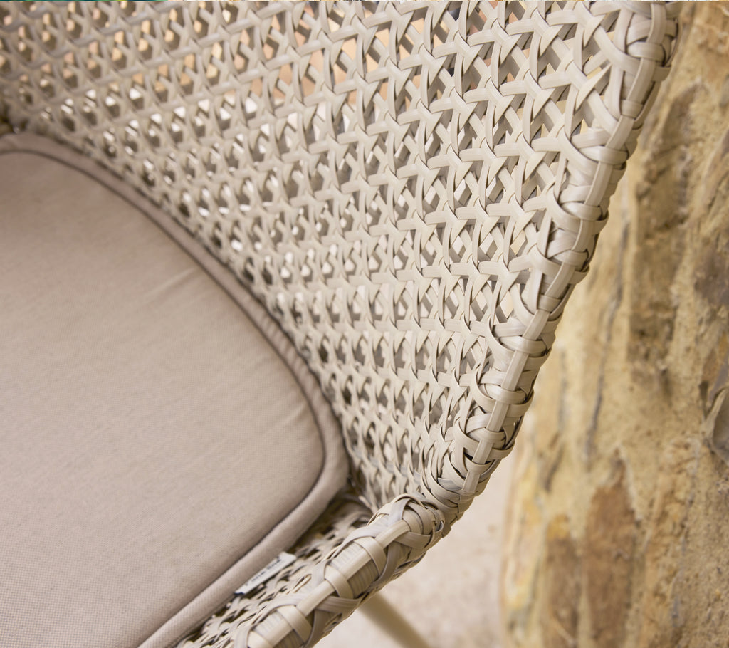 Close-up of a woven chair design featuring intricate Vibe weave and a soft cushion, showcasing texture and craftsmanship.