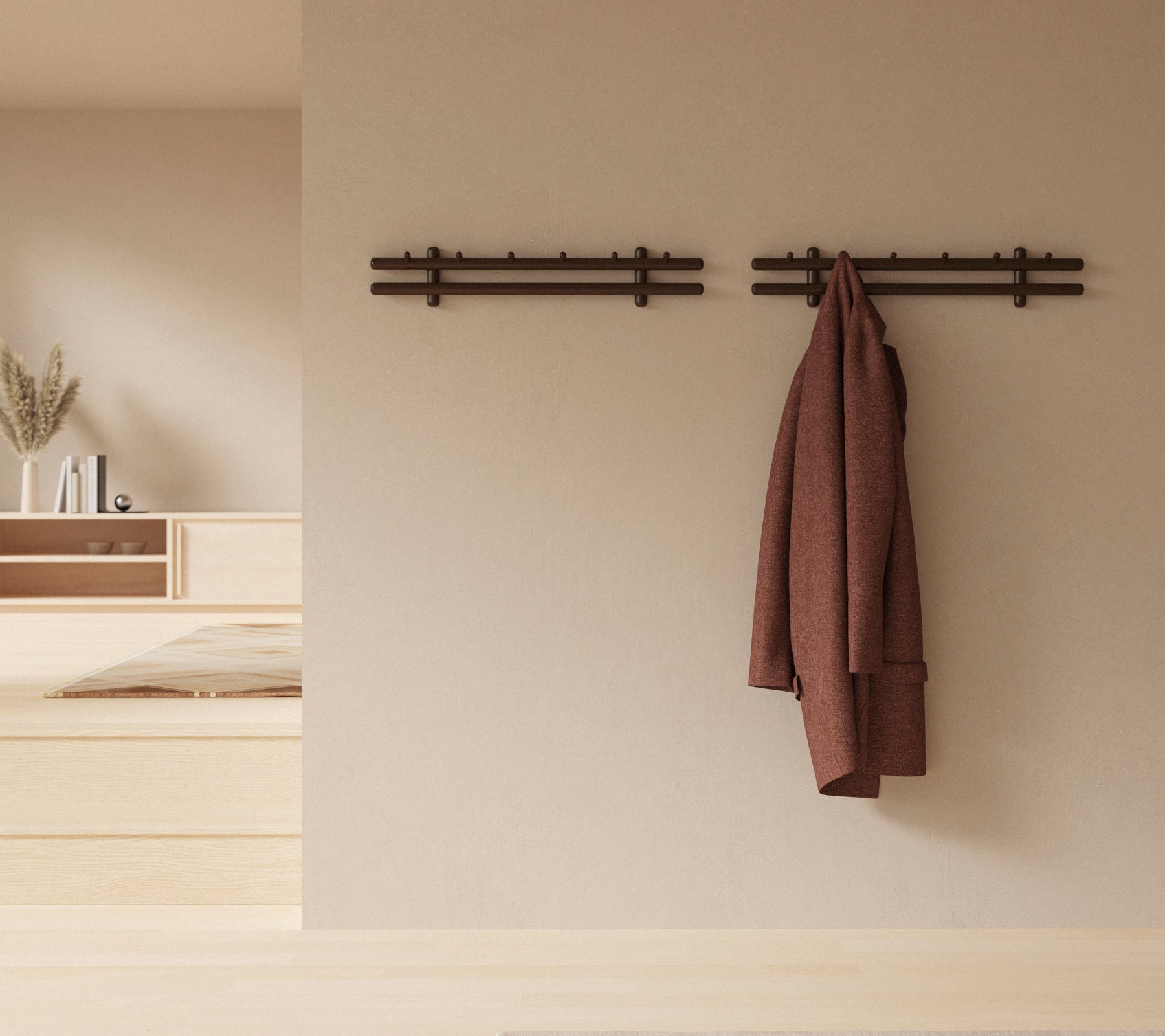 A minimalistic wall display with wooden sticks holding a coat and a gathering of rags, enhancing the rustic decor aesthetic.