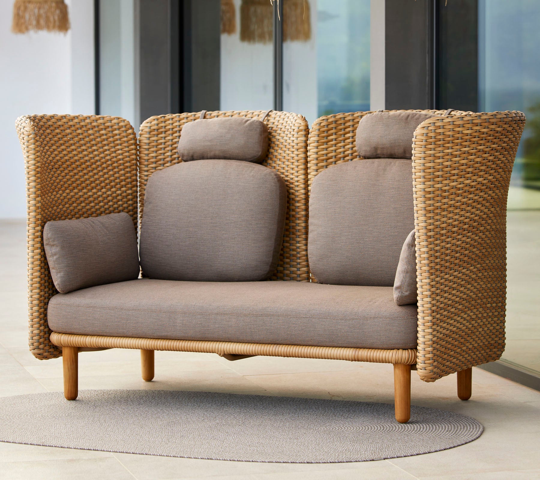 Stylish two-seater sofa with woven texture, featuring comfortable cushions and a natural wood base, ideal for relaxation.